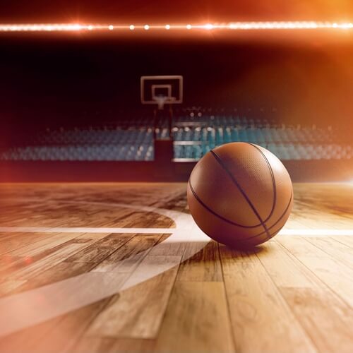 Interior,View,Of,An,Illuminated,Basketball,Stadium,For,A,Game